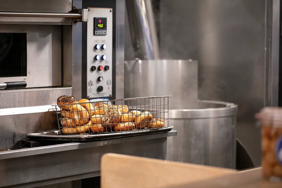 Hand-rolled bagels in a wire basket, just out of the kettle