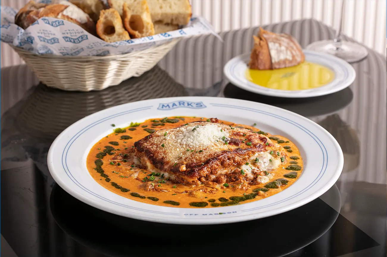 Lasagne della Nonna on a Mark’s plate, with a basket of house-baked bread